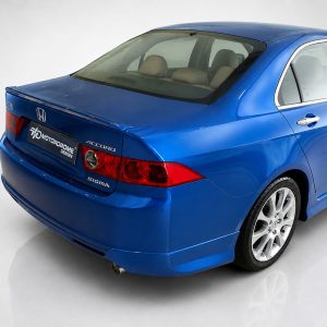 Blue Honda Accord seen from the rear in a studio setting, showing its taillights and trunk badges.
