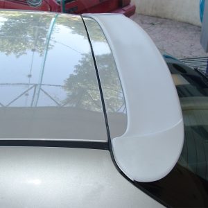 Close-up of a silver car's rear spoiler mounted above the rear window, showing its curved aerodynamic shape.
