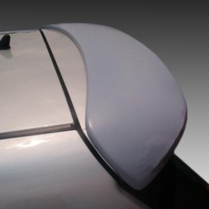 Close-up of a white car's rear spoiler with a curved edge, showing the trunk and trunk lid seam