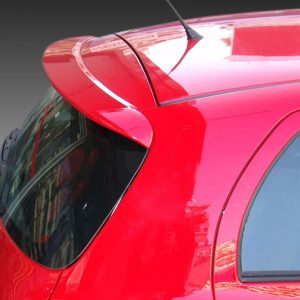 Red hatchback viewed from the back-left, showing the rear window, taillight area, and curved bodywork with a spoiler.