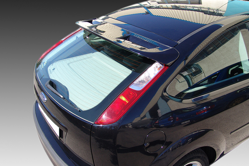 A-296_2jpg - OPSHOLDERS Top-down rear view of a dark blue hatchback car with a rear spoiler and visible taillights on a glossy surface.