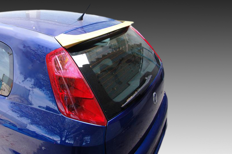 A-298_2jpg - OPSHOLDERS Rear-left three-quarter view of a blue hatchback car with a beige spoiler, taillight, and rear window wiper viewable to the back end.