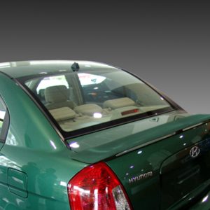 Green Hyundai sedan rear view with visible beige interior through rear window and taillights illuminated, parked indoors/near a gradient background.