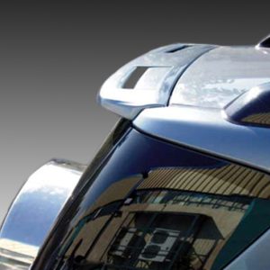 Close-up of a silver car's roof and rear window with reflections on the glossy surface