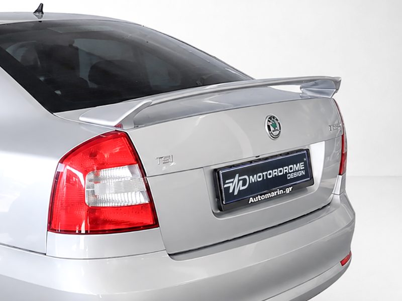 Rear view of a silver sedan showing trunk spoiler, taillight, and a dealership plate reading 'Motorodome Design'