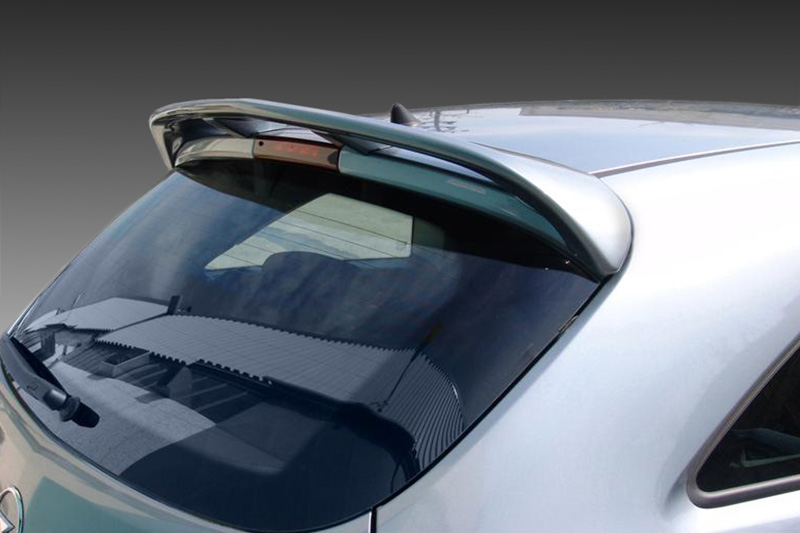 A-314_1jpg - OPSHOLDERS Rear hatch window of a silver car with a curved roof spoiler and wiper visible at the bottom edge of the window area.