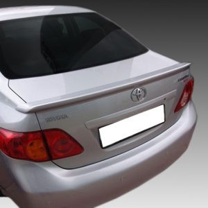 Rear view of a white Toyota sedan with spoiler, taillights visible and license plate obscured by a white block.