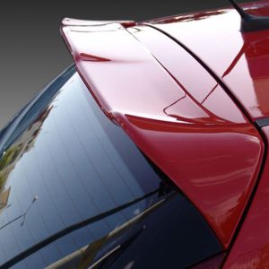 Close-up of a red car's rear spoiler and glossy trunk area, reflecting surroundings.