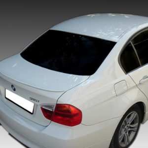 Rear three-quarter view of a white BMW 316i sedan, showing the trunk, rear taillights, and alloy wheels