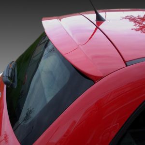 Close-up of a red car's rear roof and window, with a spoiler and antenna visible.