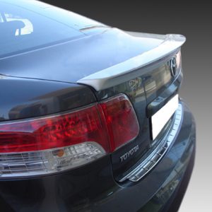 Rear view of a black Toyota sedan showing the trunk spoiler and red tail lights, parked outdoors