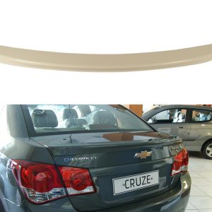 Beige curved car spoiler above a showroom scene featuring a gray Chevrolet Cruze rear and another car in the background.