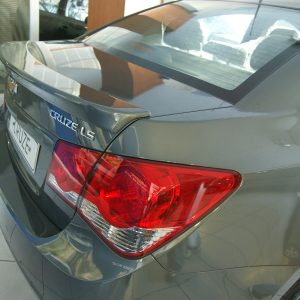 Rear view of a gray Chevrolet Cruze LT in a showroom, showing taillights and trunk badge.