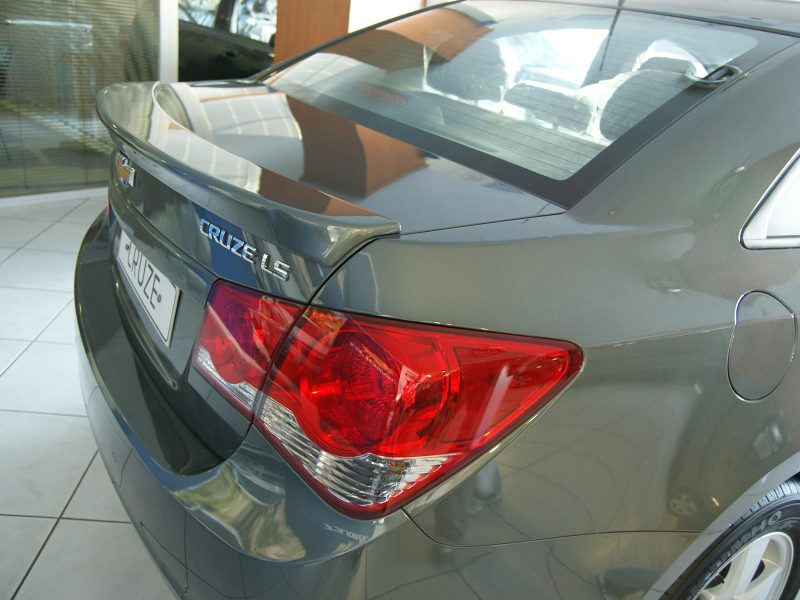 Rear view of a gray Chevrolet Cruze LT in a showroom, showing taillights and trunk badge.