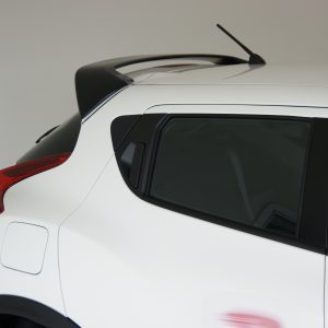 SONY DSC - OPSHOLDERS White SUV rear quarter with black rooftop spoiler, antenna, and red tail light visible on the left side.