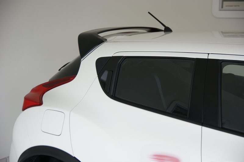 SONY DSC - OPSHOLDERS White SUV rear quarter with black rooftop spoiler, antenna, and red tail light visible on the left side.