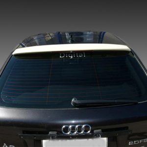Rear view of a black Audi hatchback with a spoiler and visible Audi emblem, blurred license plate in the foreground, 'Digital' on the rear window opener (windshield).