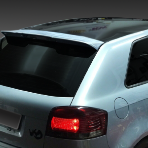 Rear three-quarter view of a silver Audi hatchback with red tail light illuminated and spoiler, on a dark gradient background