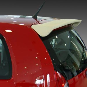 Rear view of a red hatchback with a white spoiler on the roof, viewed from the left side.