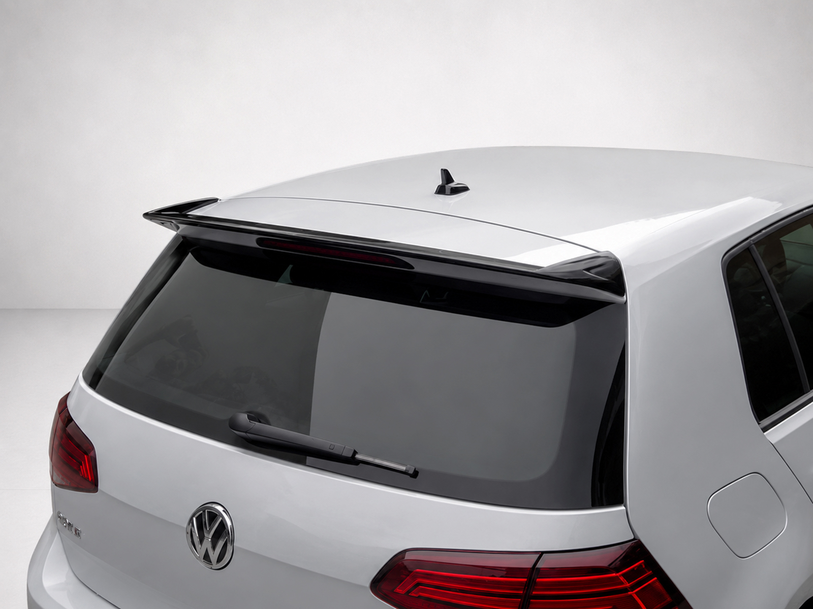 A-403_1jpg - OPSHOLDERS Rear view of a silver Volkswagen hatchback showing a roof spoiler and rear windshield wiper, badge visible on the tailgate