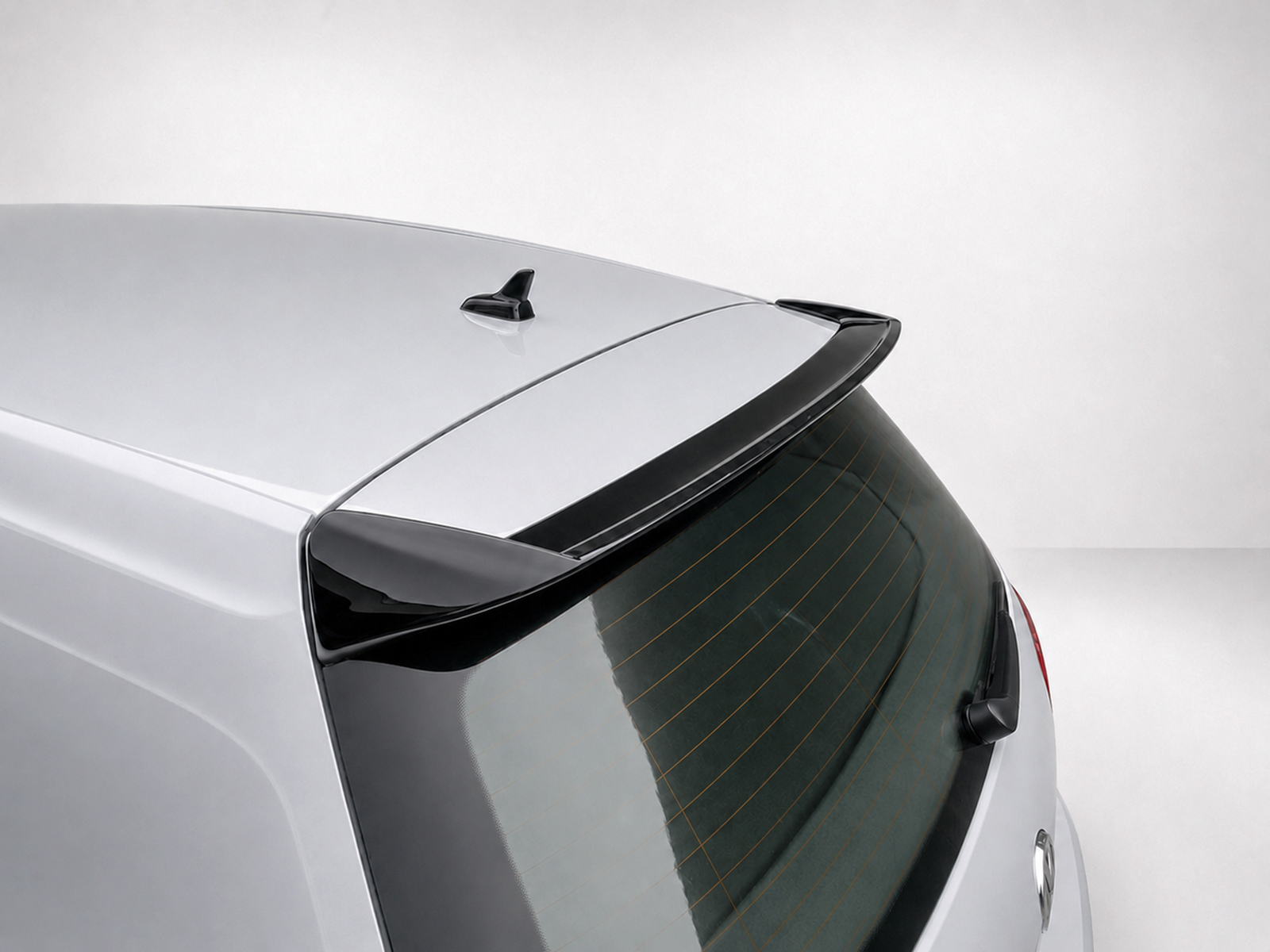 A-403_2jpg - OPSHOLDERS Rear view of a silver hatchback showing a roof spoiler and small antenna on the roof edge, with the rear window and wiper visible.