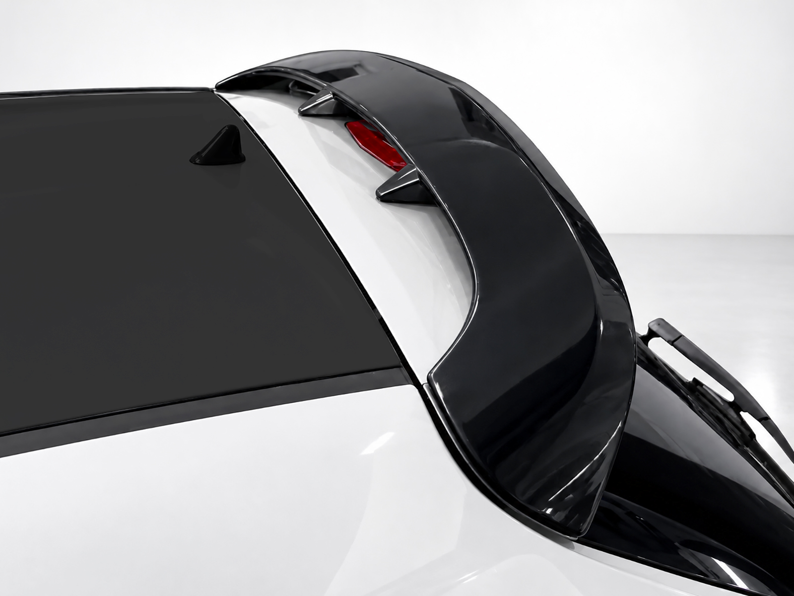 A-407_2jpg - OPSHOLDERS Close-up of a high-gloss black car roof, rear window, and spoiler with a wiper on the lower right edge.