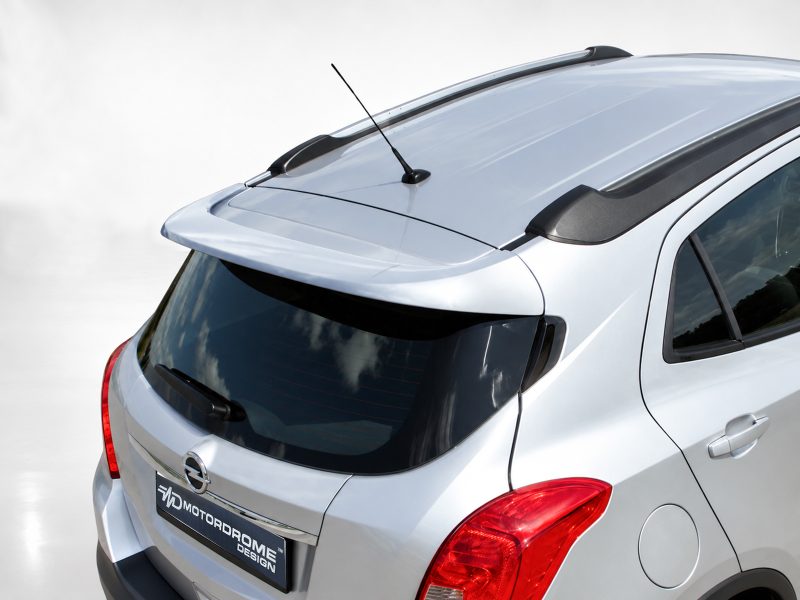 A-409_2jpg - OPSHOLDERS Rear view of a silver SUV featuring a roof spoiler, antenna, and prominent red taillights.