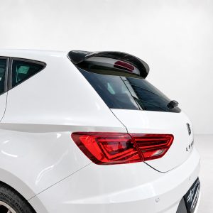Rear-left view of a white hatchback with a small spoiler, red taillights, and a rear wiper in place.
