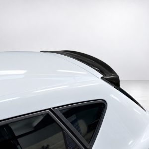 Close-up of a white car roof with a black aerodynamic spoiler along the rear edge.