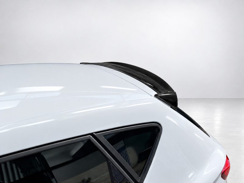 Close-up of a white car roof with a black aerodynamic spoiler along the rear edge.