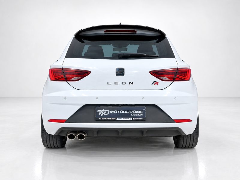 Rear view of a white SEAT Leon FR hatchback in a studio setting, showing taillights and dual exhausts intact at the left. Review: no people visible.