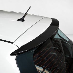 Close-up of the rear of a white hatchback, showing the roof antenna and curved rear window with defroster lines.