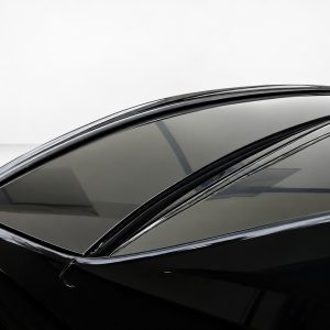 Close-up of a black car roof with a panoramic glass sunroof.