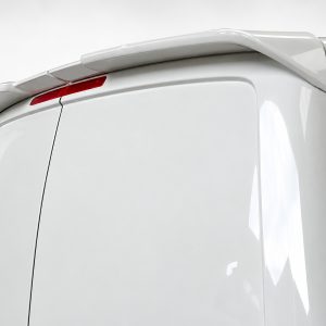 A-418_2jpg - OPSHOLDERS White van rear corner with roof spoiler and red rear brake light, close-up view.