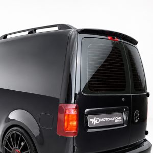 Black van rear quarter with a roof rack,burnished black finish and tinted rear window with defroster lines visible on the glass