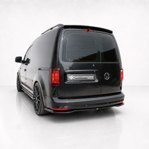 Rear three-quarter view of a black customized Volkswagen van with aftermarket wheels and a Motordrome Design badge.
