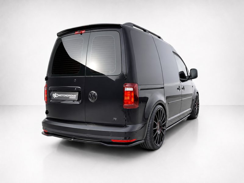 Black cargo van with dark tinted rear windows and oversized black alloy wheels, photographed from the rear-right."]} ,{