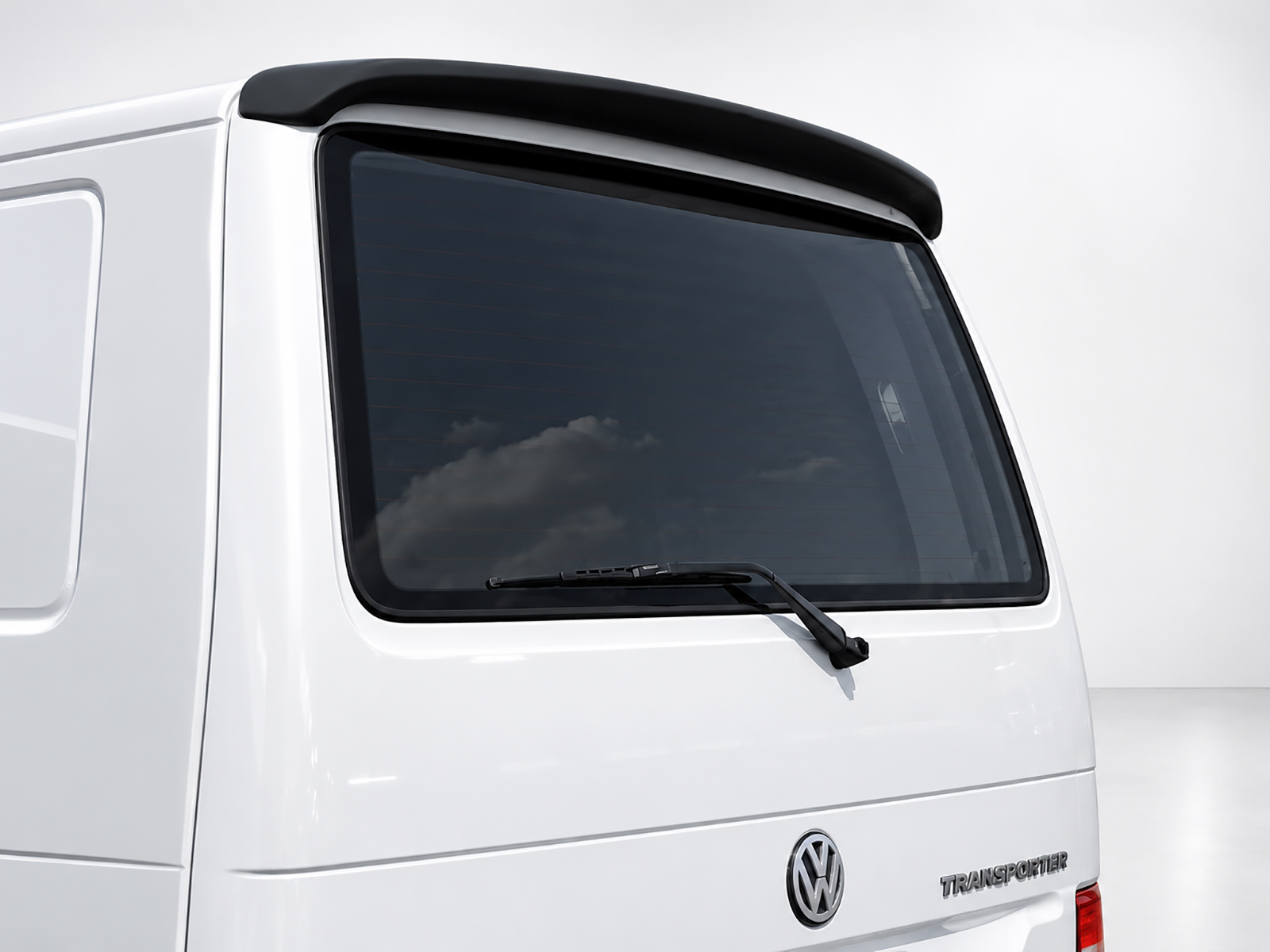 A-421_1jpg - OPSHOLDERS Rear quarter view of a white VW Transporter van, showing the rear window with wiper and a small roof spoiler.