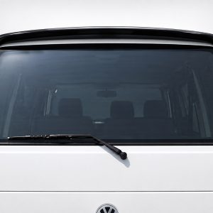 A-421_3jpg - OPSHOLDERS Rear window of a white vehicle with a bottom-mounted windshield wiper and a dark-tinted glass.