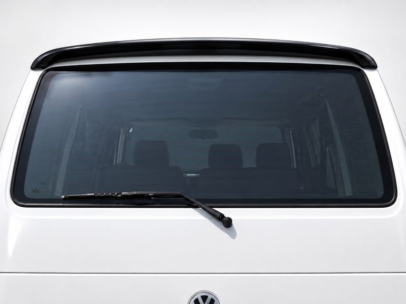 A-421_3jpg - OPSHOLDERS Rear window of a white vehicle with a bottom-mounted windshield wiper and a dark-tinted glass.