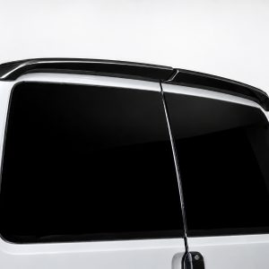 Close-up of a white SUV's rear window with a black roof spoiler above it.