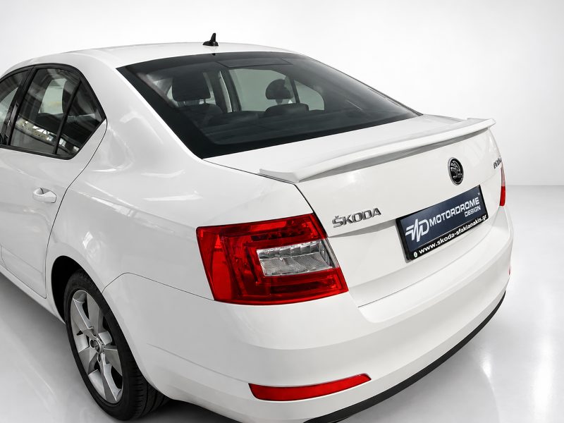 A-429_3jpg - OPSHOLDERS Rear three-quarter view of a white Škoda sedan, showing the trunk spoiler, taillights, and emblem.