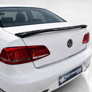 A-432_2jpg - OPSHOLDERS White Volkswagen sedan rear view with a black spoiler and red tail lights in a studio setting, logo visible on trunk badge