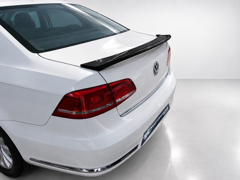 A-432_3jpg - OPSHOLDERS Rear view of a white Volkswagen sedan, featuring a black spoiler and red tail lights in a studio setting.