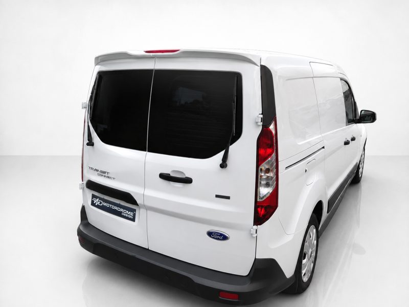 Rear-left view of a white Ford Transit cargo van in a bright studio setting.