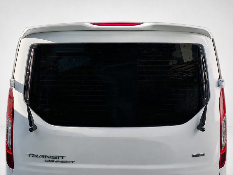 A-441_3jpg - OPSHOLDERS Rear view of a white Ford Transit Connect van with a large rear window and two wiper blades visible on the tailgate.