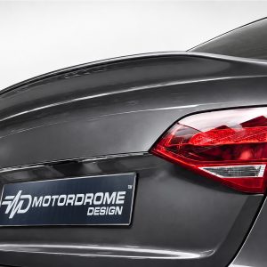 A-443_5jpg - OPSHOLDERS Rear corner of a dark gray car, red taillight visible and a Motordrome Design plate on the bumper.