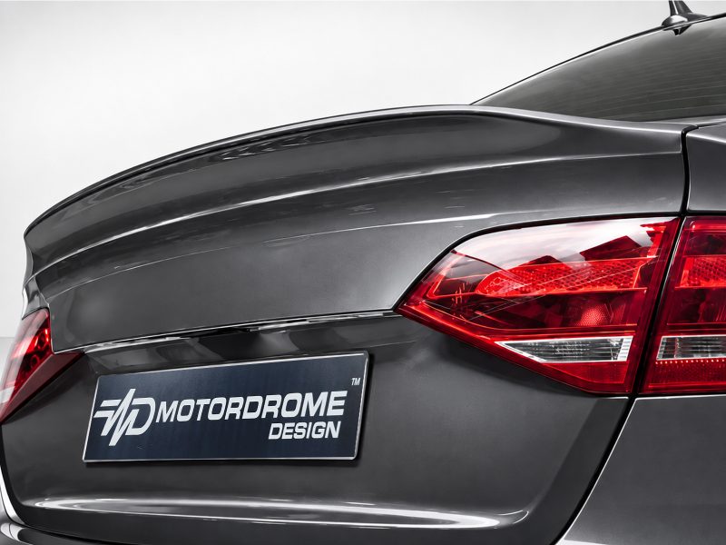A-443_5jpg - OPSHOLDERS Rear corner of a dark gray car, red taillight visible and a Motordrome Design plate on the bumper.