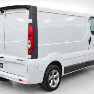 Rear-right view of a white Renault Trafic cargo van with twin back doors and red taillights in a studio setting.