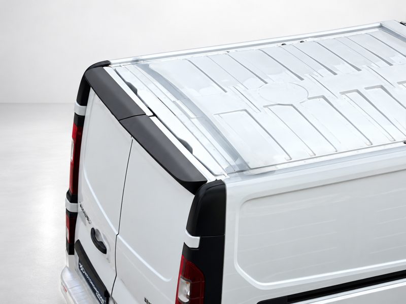 Rear-right view of a white cargo van with a metal-toned roof rack and black trim details behind the rear door.